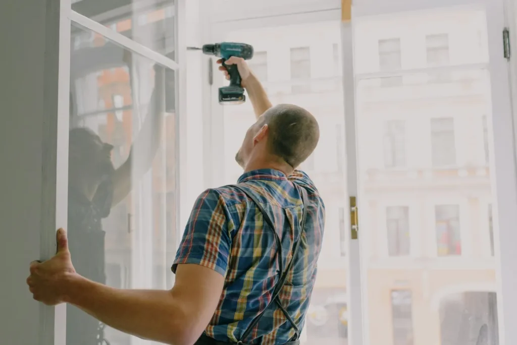 Contractor installing a replacement window during home restoration