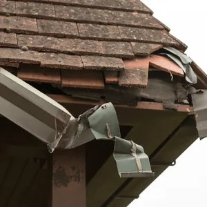 Storm damage to a residential roof edge and gutter